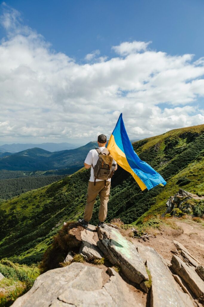 A tourist on the mountains with a ukrainian flag